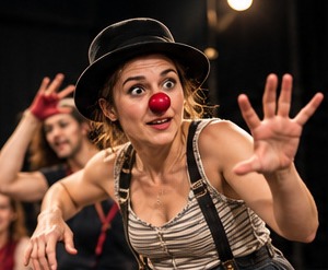Clownerie mit roter Nase, Hut und Hosenträgern